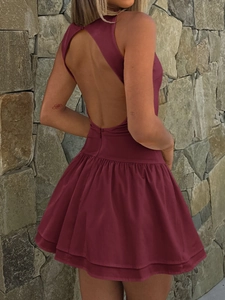 Detail of wine red sleeveless halter dress with open back design and ruffled hemline