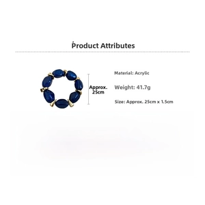 Detail of dark blue acrylic oval beaded bracelet with gold spacers on white background