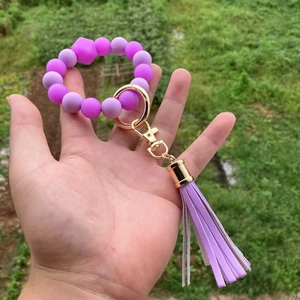 Dettaglio del portachiavi a polso in perle di silicone viola con nappa in pelle PU e chiusura