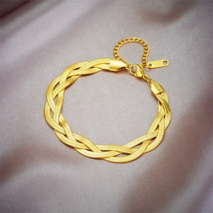Macro shot of gold woven titanium steel bracelet showing detailed K18 tag and lobster clasp