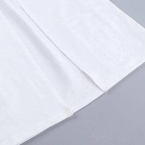 Gros plan détaillé sur la fente latérale et la texture du tissu blanc de la robe d'été
