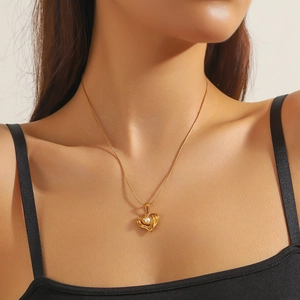 Minimalist gold heart pendant necklace with pearl inlay, elegantly worn on the neck