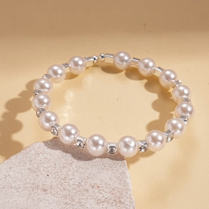 Détail de perles d'imitation rondes et d'accents diamantés sur un bracelet à perles argenté
