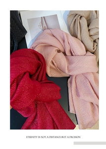 Dettaglio della trama del foulard plissettato glitterato nei colori rosso, rosa e oro chiaro