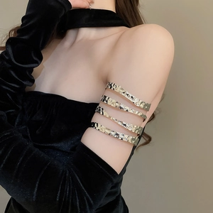 Detailed view of golden multi-layer arm cuff with hammered texture on upper arm