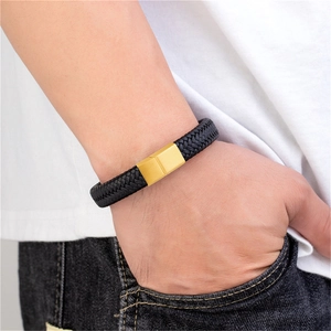 Detail eines Herren-Lederarmbands in Schwarz mit Goldverschluss am Handgelenk