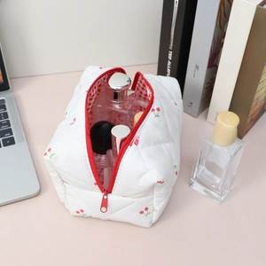 Detail of quilted floral makeup bag with cherry pattern and secure red zipper closure