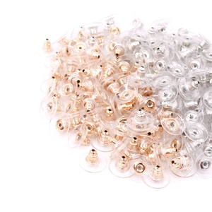 Clear silicone earring backs with gold and silver metal cores in a bulk stack