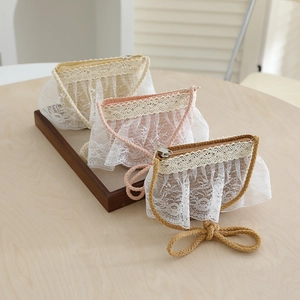 Detailed macro view of children's straw bags with floral lace trim and zip closure