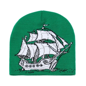 Gros plan du bonnet en tricot vert avec un motif de voilier jacquard noir et blanc net