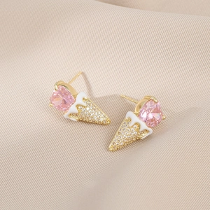 Macro shot of gold ice cream stud earrings with pink heart stone and zircon pave