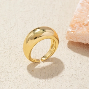 Macro detail of a minimalist gold-plated ring with polished finish on textured background
