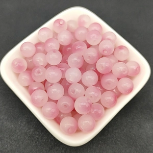 Close-up of translucent pink 8mm round glass beads for DIY jewelry making and crafts