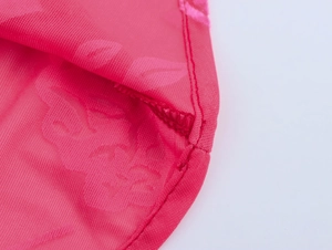 Détail de maille rose avec motif jacquard floral et coutures de bordure fines