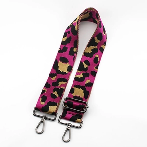 Close-up of leopard print adjustable bag strap with metallic hooks on white background