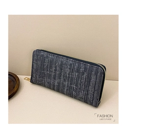 Close-up of grey striped long wallet with golden zipper on a warm beige background