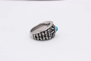 Détail macro d'une bague vintage en acier pour homme avec une pierre turquoise ronde