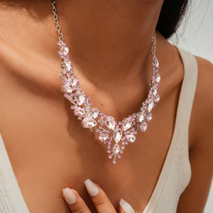 Macro view of luxurious pink crystal teardrop flower necklace worn on model's neck