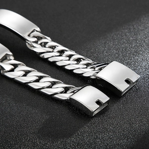 Detalle macro de pulsera de cadena cubana de acero pulido con cierre cuadrado seguro