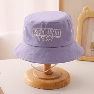 Detailed view of lavender bucket hat with embroidered letters and smiling face design
