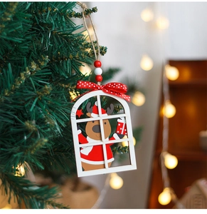 Detail of wooden Christmas reindeer ornament hanging on a festive tree branch