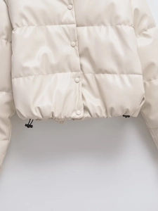 Detail of cream white PU leather jacket featuring snap buttons and adjustable drawstring hem