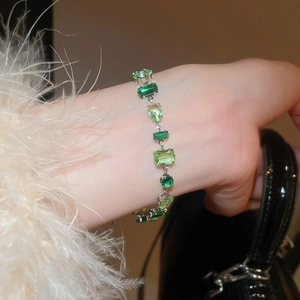 Macro shot of silver bracelet with various green zircon stones in geometric shapes