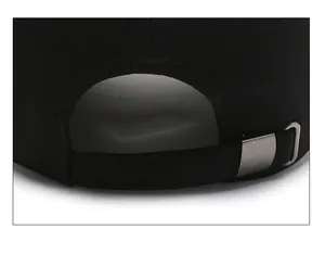 Detail of black baseball cap showing the adjustable metal buckle and twill fabric