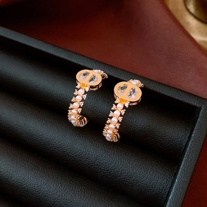 Detail of 18k gold plated CD earrings with pearls and zircon in a black jewelry box