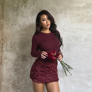 Détail d'une robe bordeaux à manches longues avec fleurs 3D et taille ajustée