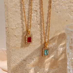 Detailed close-up of gold water wave chain with red and blue zircon square pendants
