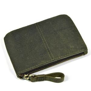 Close-up of deep green leather coin purse showing vintage texture and metal zipper detail