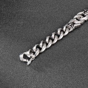 Close-up of polished silver stainless steel Cuban chain link bracelet on black background