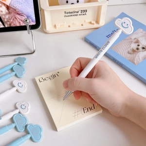 Close-up of white retractable gel pen featuring a cute 3D smiling cloud topper decoration