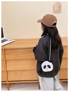 Toddler girl wearing a cute plush panda crossbody bag over a casual sweatshirt