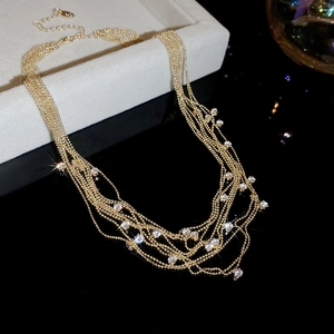Detailed macro view of multi-layer gold bead necklace with sparkling zircon tassels