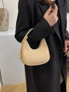 Chic beige felt dumpling shoulder bag with crocodile texture and gold hardware on model