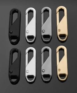 Macro view of metallic zipper pull replacements in black, silver, gunmetal, and gold