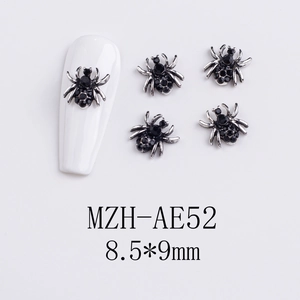 Macro shot of silver spider nail charms with black rhinestones on white nail tips