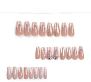 Detailed view of nude pink French tip press-on nails with glitter and crown rhinestone accents