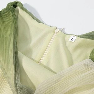 Detail view of the light green pleated mesh fabric with a zipper and size L label