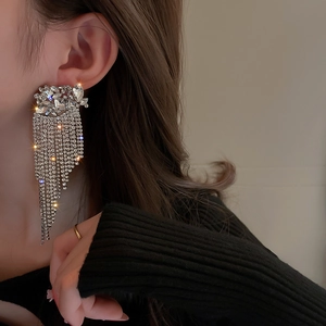 Close-up of model wearing silver flower tassel earrings with sparkling rhinestone crystals