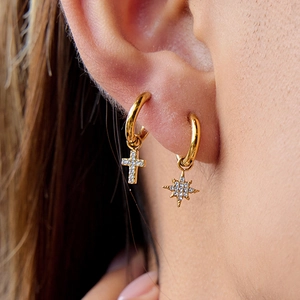 Gold hoop earrings with star and cross charms featuring sparkling clear crystals