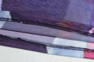 Detailed macro view of the purple mesh fabric stitching and fine hem edge workmanship