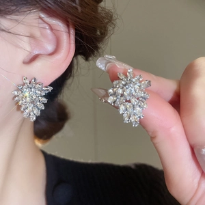 Close-up of silver leaf stud earrings with sparkling cubic zirconia on a model