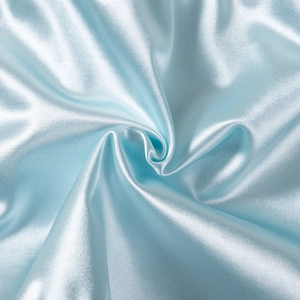 Macro shot of light blue silky satin fabric texture showing smooth reflective ripples