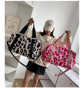 Waterproof cow print travel tote bags in black and pink displayed in modern interior