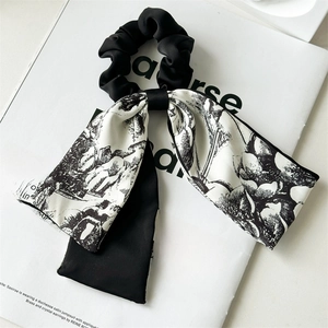 Detail of elegant black satin hair scrunchie with vintage floral pattern ribbon