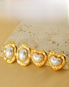 Detail of 18K gold plated earrings featuring pearl inlay and heart oval crinkle textures