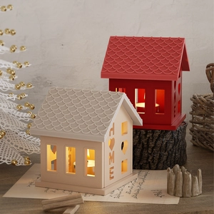Close-up of HOME house-shaped silicone candle holder with hollow heart and warm light